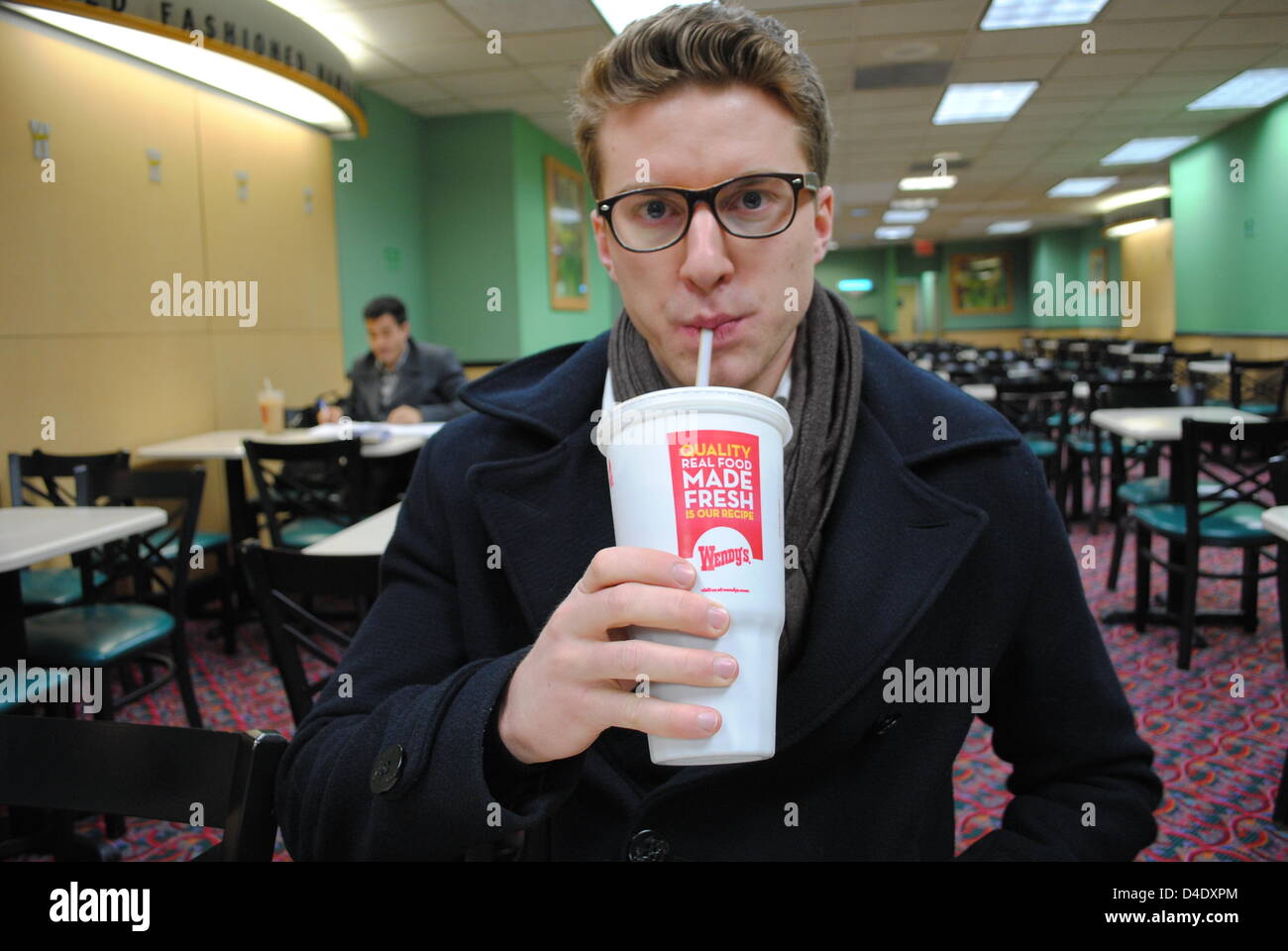 Un étudiant de boissons dans une grande tasse de soude dans une école de fast food restaurant à New York, USA, 11 mars 2013. Le maire de New York Michael Bloomberg voulait lutter contre l'obésité chez les Américains. Maintenant, la cour a mis un terme à la nouvelle réglementation. Photo : CASPAR TOBIAS FABIENNE Lopez-bouchet ) Banque D'Images