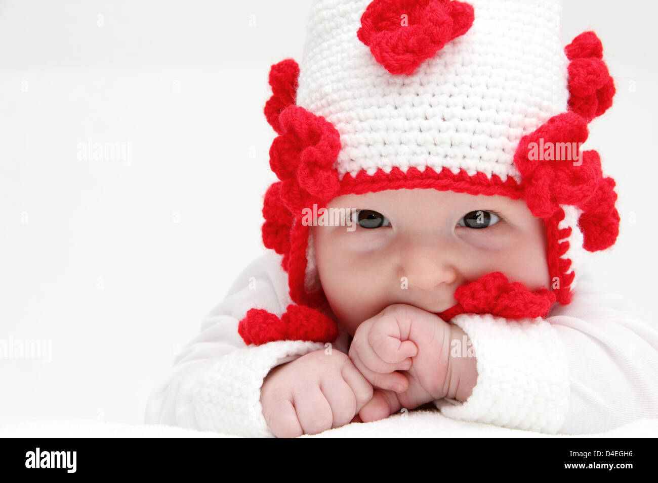 Petit bébé avec chapeau blanc tricotés sur le ventre de bébé Banque D'Images