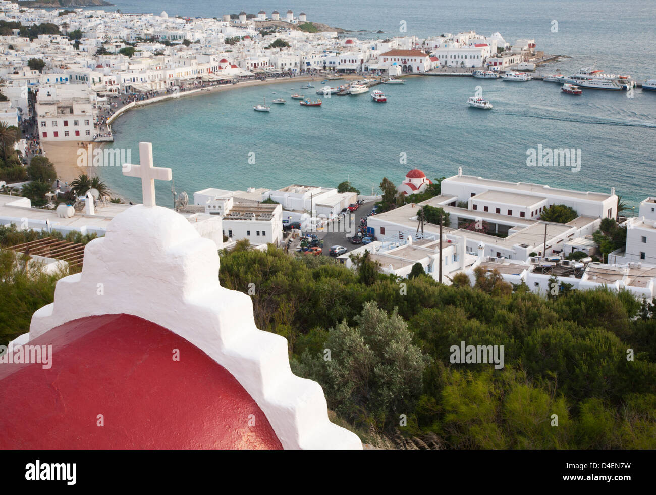 Église en dôme rouge avec croix blanche surplombant le port de Mykonos et la ville de Chora dans les îles grecques Banque D'Images
