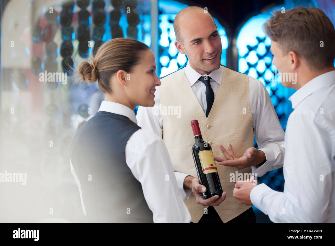 Serveurs discuter de bouteille de vin au restaurant Banque D'Images