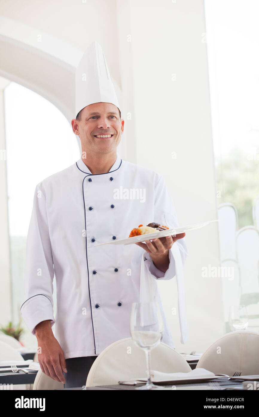 Chef holding plate of food in restaurant Banque D'Images