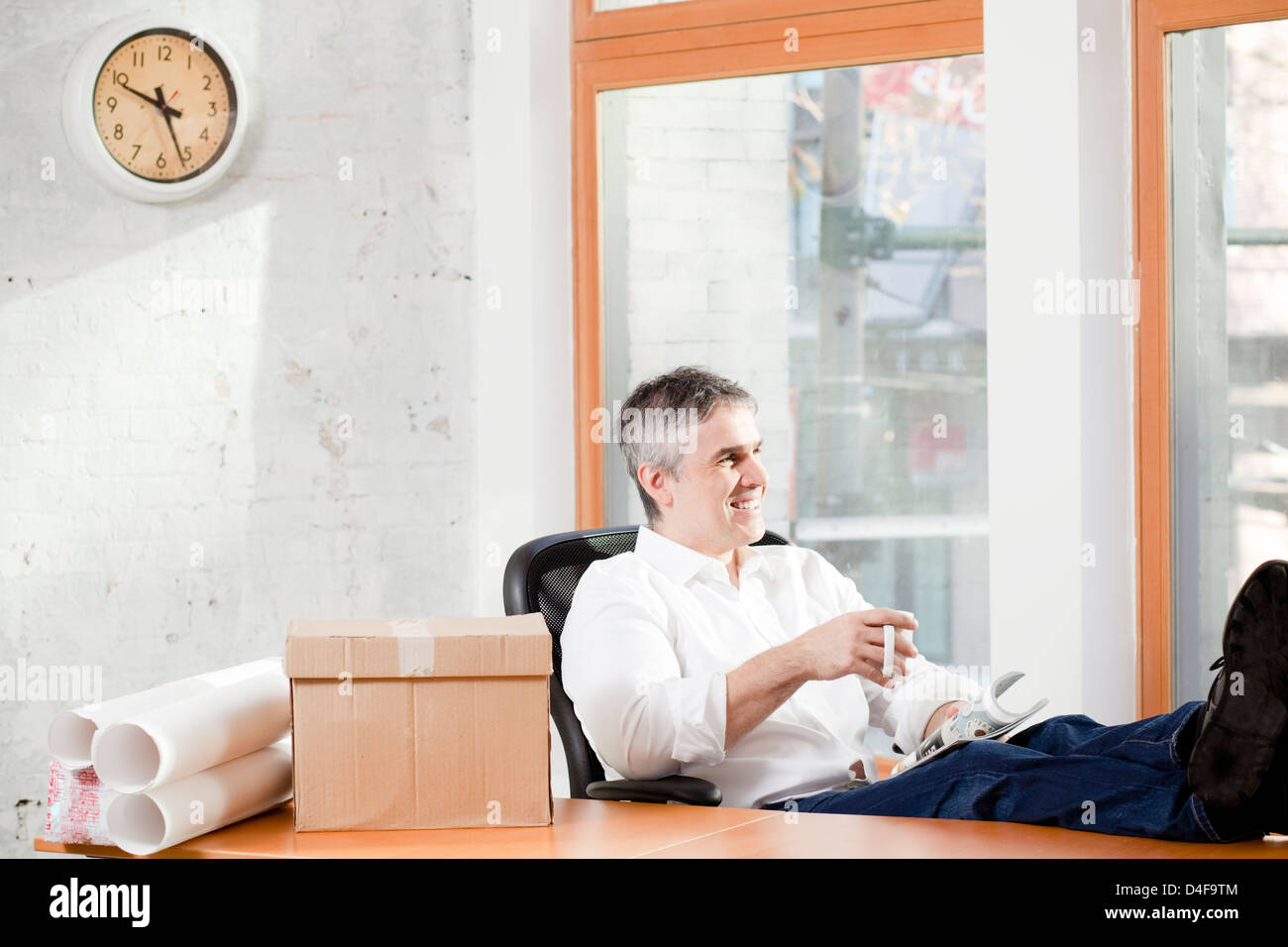 Businessman relaxing at desk in office Banque D'Images