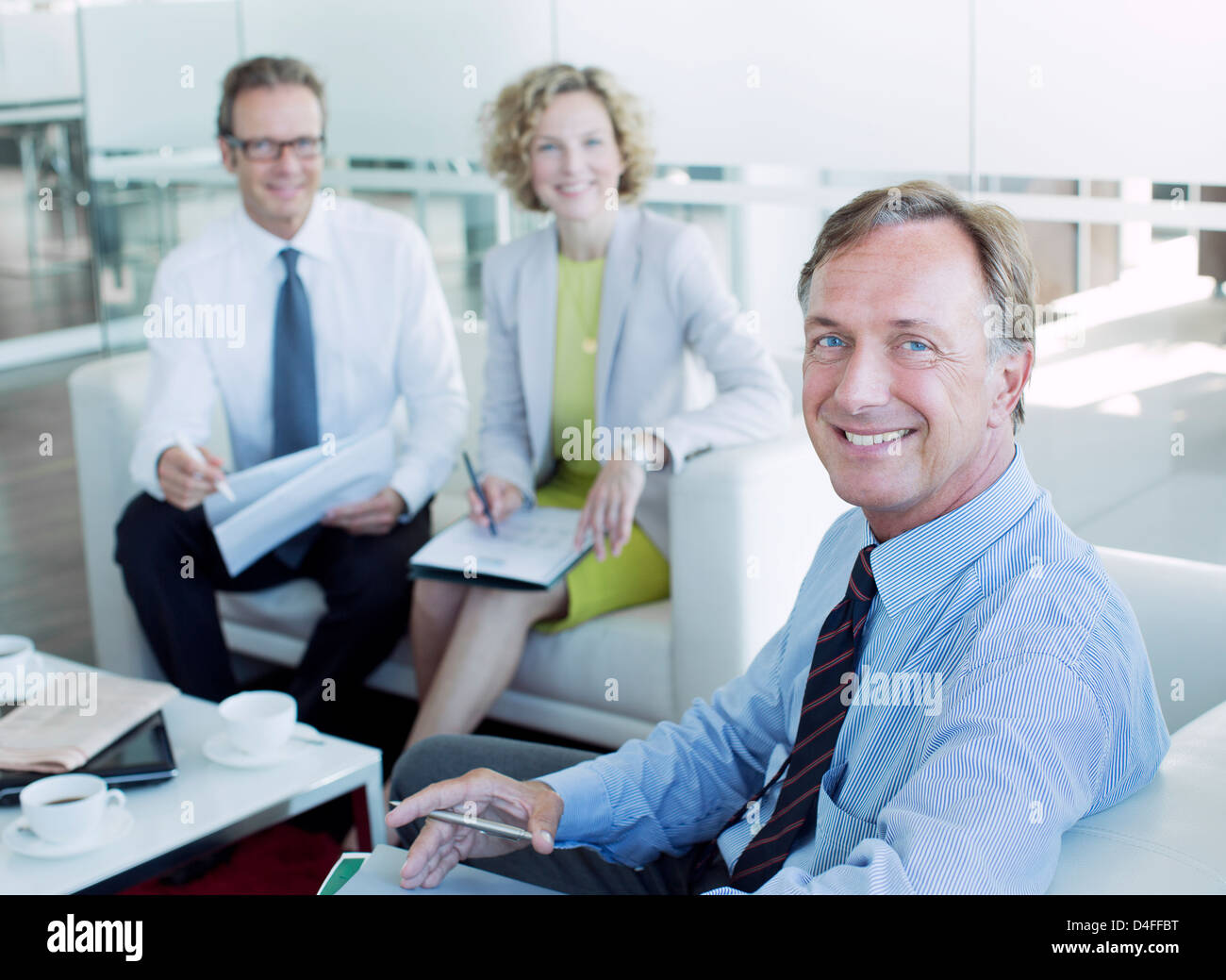 Business people smiling in office lobby Banque D'Images