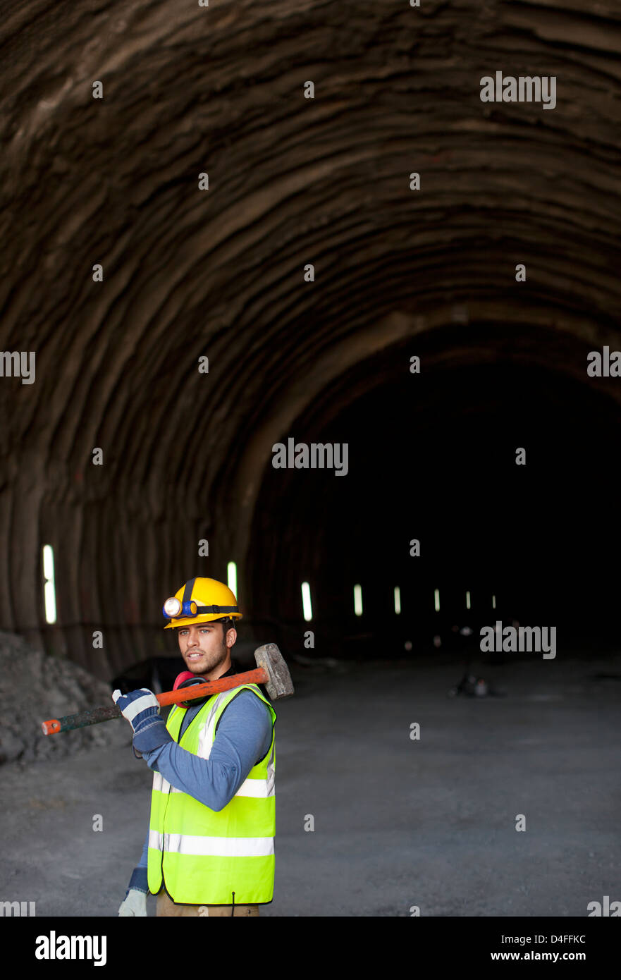 Worker holding sledgehammer dans tunnel Banque D'Images