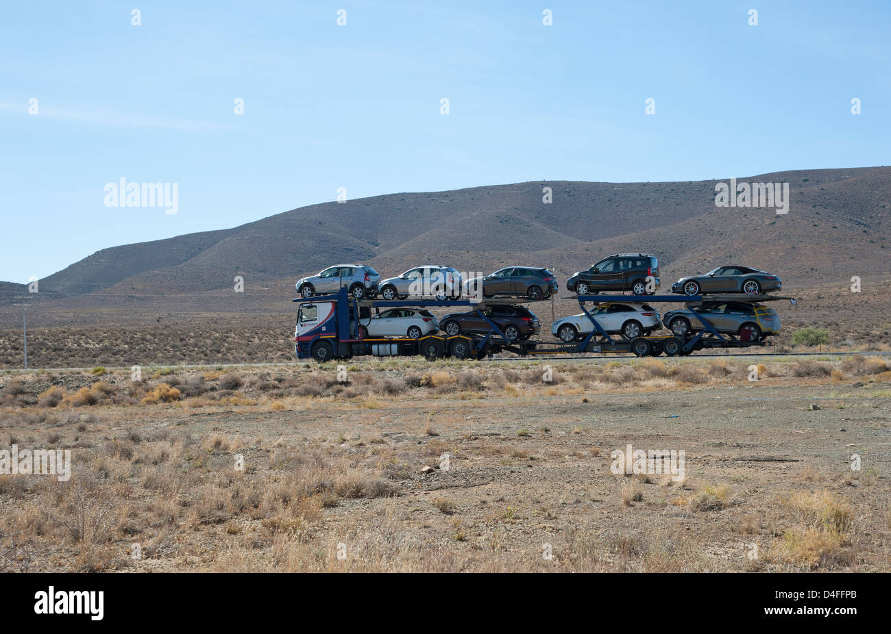 Voiture avec un plein chargement de véhicules circulant sur la N1 à un Lainsburg ville du Karoo, Afrique du Sud Banque D'Images