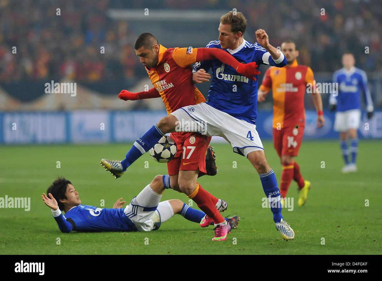 Le Schalke Atsuto Uchida (ci-dessous) et Benedikt Hoewedes (R) vie de la balle avec le Galatasaray Burak Yilmaz au cours de l'UEFA Champions League round 16 match retour de match de football entre le FC Schalke 04 et galatasaray Istanbul à la Veltins-Arena de Gelsenkirchen, Allemagne, 12 mars 2013. Photo : Revierfoto Banque D'Images