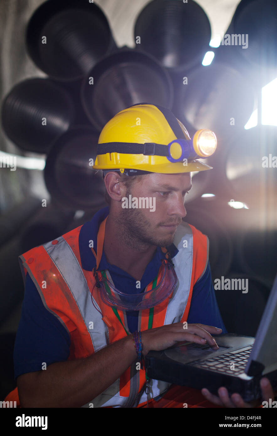 Worker using laptop in tunnel Banque D'Images