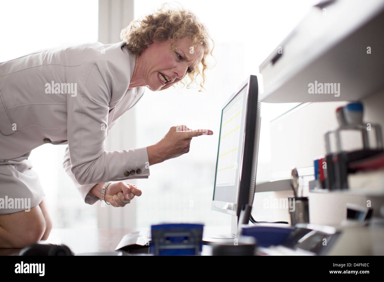 Businesswoman yelling at computer in office Banque D'Images