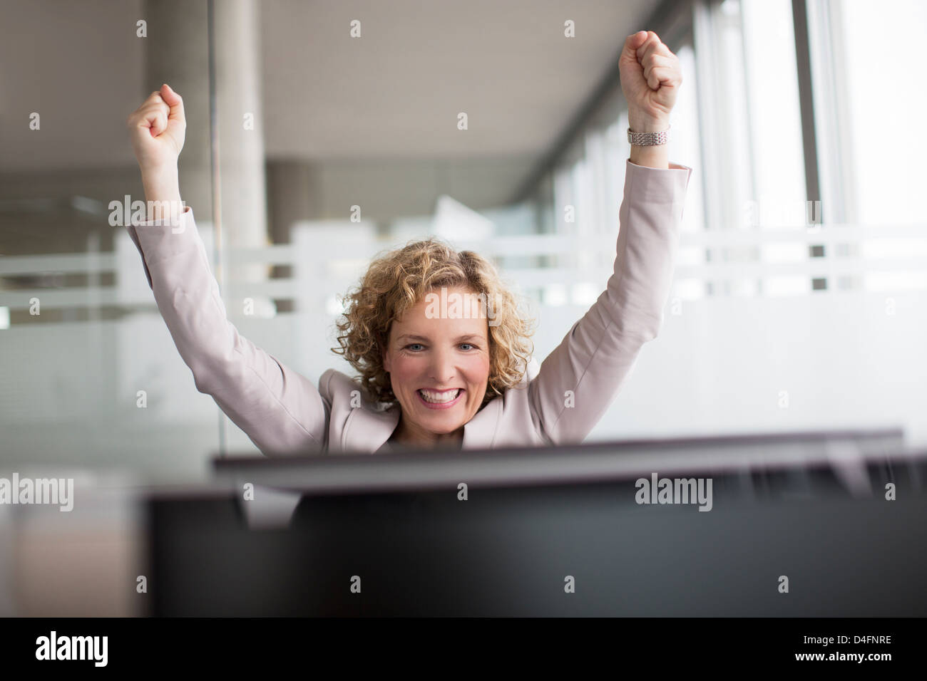 Businesswoman cheering in office Banque D'Images