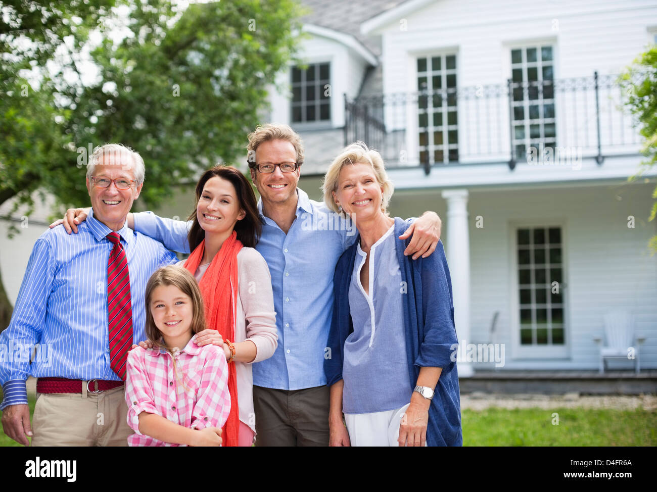 Family smiling together outside house Banque D'Images