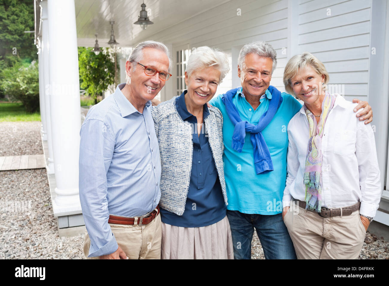 Friends Standing together outside house Banque D'Images