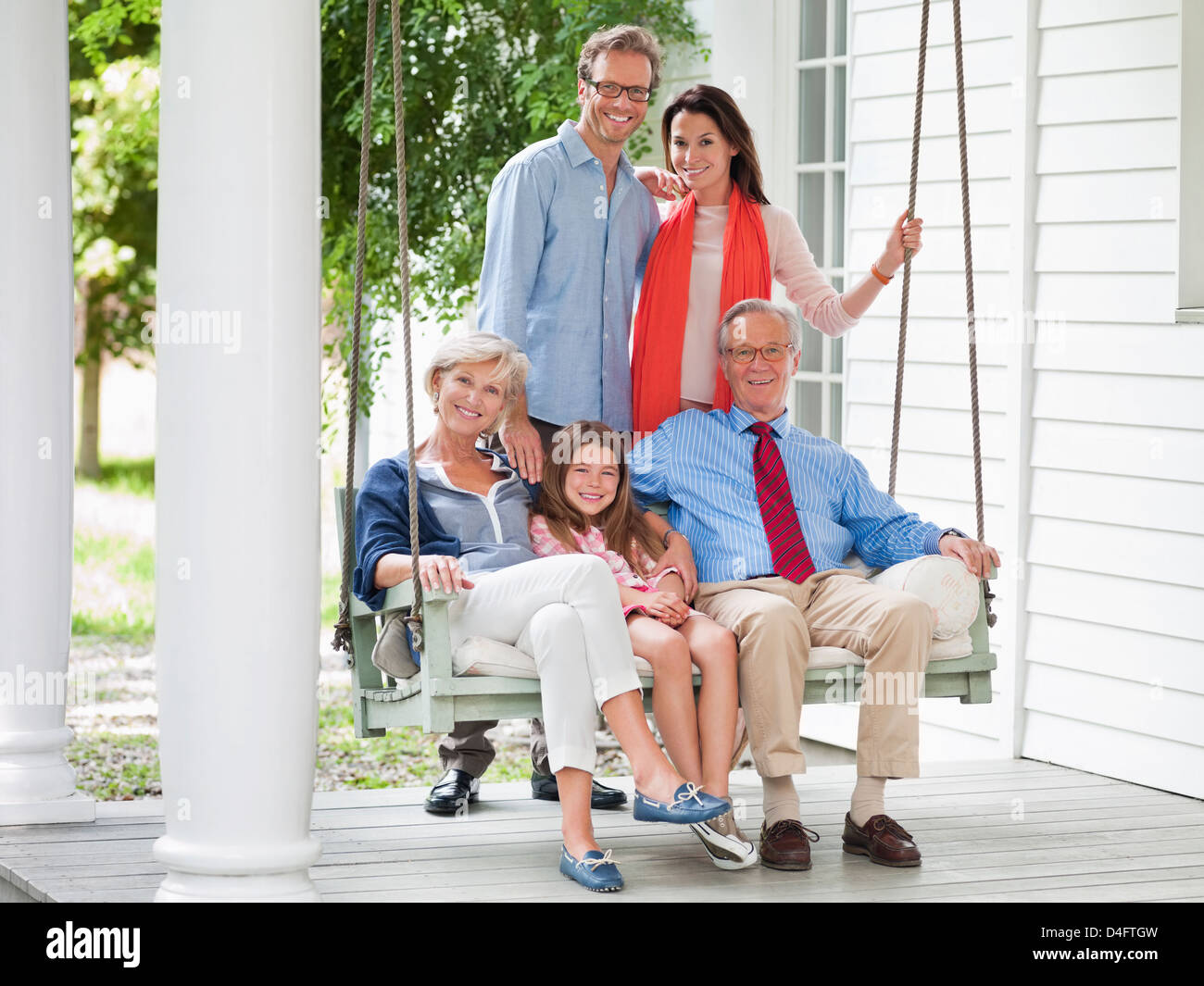 Family smiling together on porch Banque D'Images