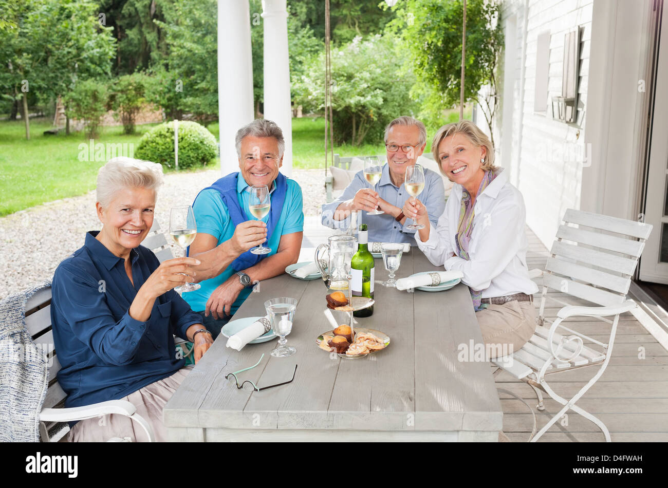 Friends toasting each other with wine at table Banque D'Images