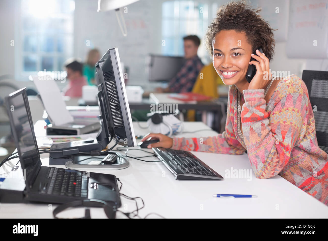 Businesswoman talking on phone at desk Banque D'Images