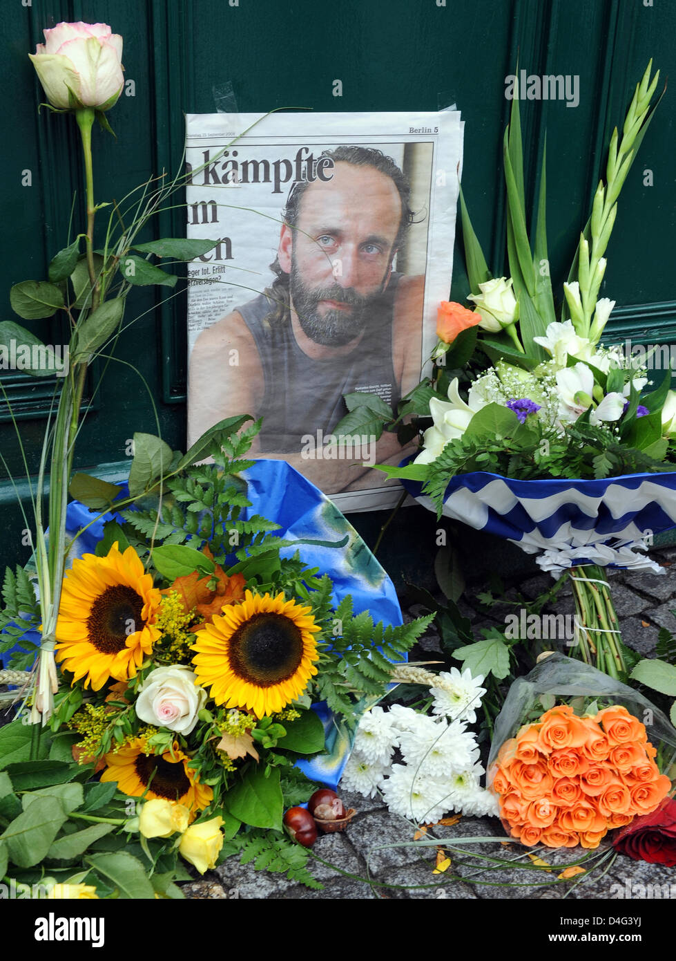 Des fleurs et une photo de Thomas Doerflein décédé, père adoptif de l'ours polaire Knut, sont vus à l'entrée du zoo de Berlin, Allemagne, 23 septembre 2008. 44 ans Doerflein a été retrouvé mort à son appartement le 22 septembre. Le gardien de zoo avait nourri au biberon et Knut -qui a été rejeté par sa mère. Photo : Gero Breloer Banque D'Images