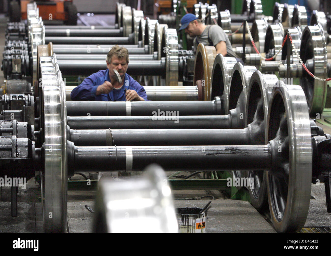 Les employés des usines d'Autorail SFW Delitzsch Ltd. Les travaux sur les essieux montés à l'usine de la compagnie dans la région de Delitzsch, Allemagne, 23 septembre 2008. La société, célèbre son 100e anniversaire de la production sur le site, est spécialisée dans la révision, re-design, les services mobiles et de l'entretien des véhicules de passagers transport ferroviaire. Les clients de l'entreprise de 230 employés sont principalement des opérateurs d'autorail en ge Banque D'Images