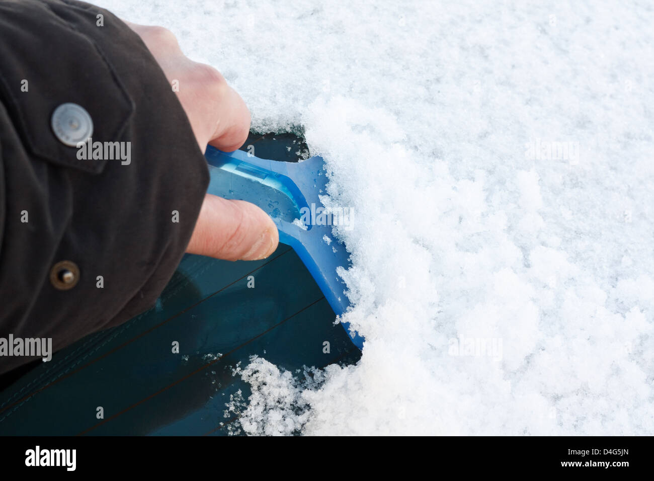 Grattoir à glace pare-brise de la compensation après de fortes chutes de neige pour la conduite sécuritaire en hiver sur un matin glacial avec copie espace à droite Banque D'Images