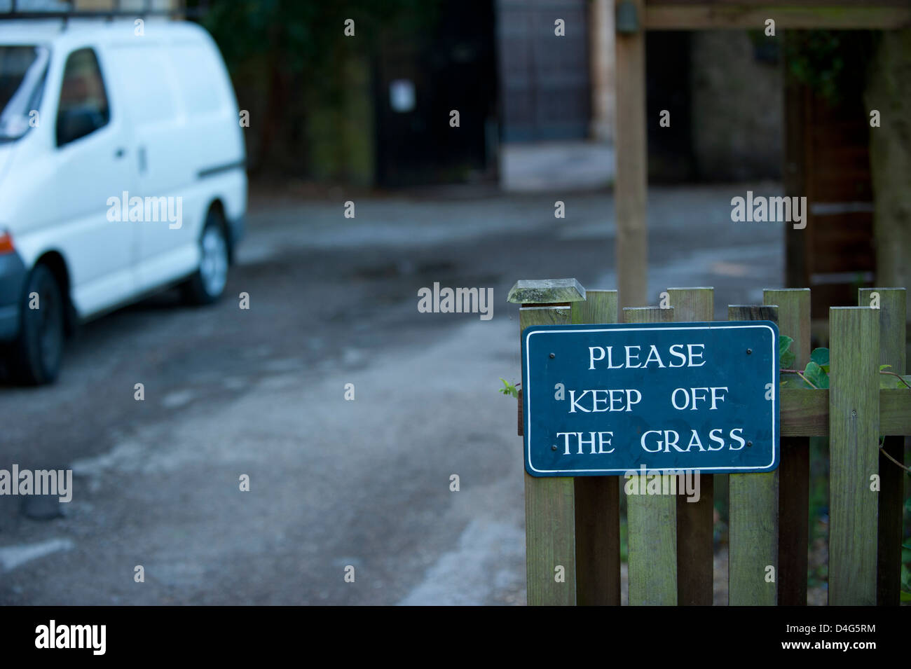 Restez à l'écart l'herbe signe avec chemin de béton à l'arrière-plan Banque D'Images