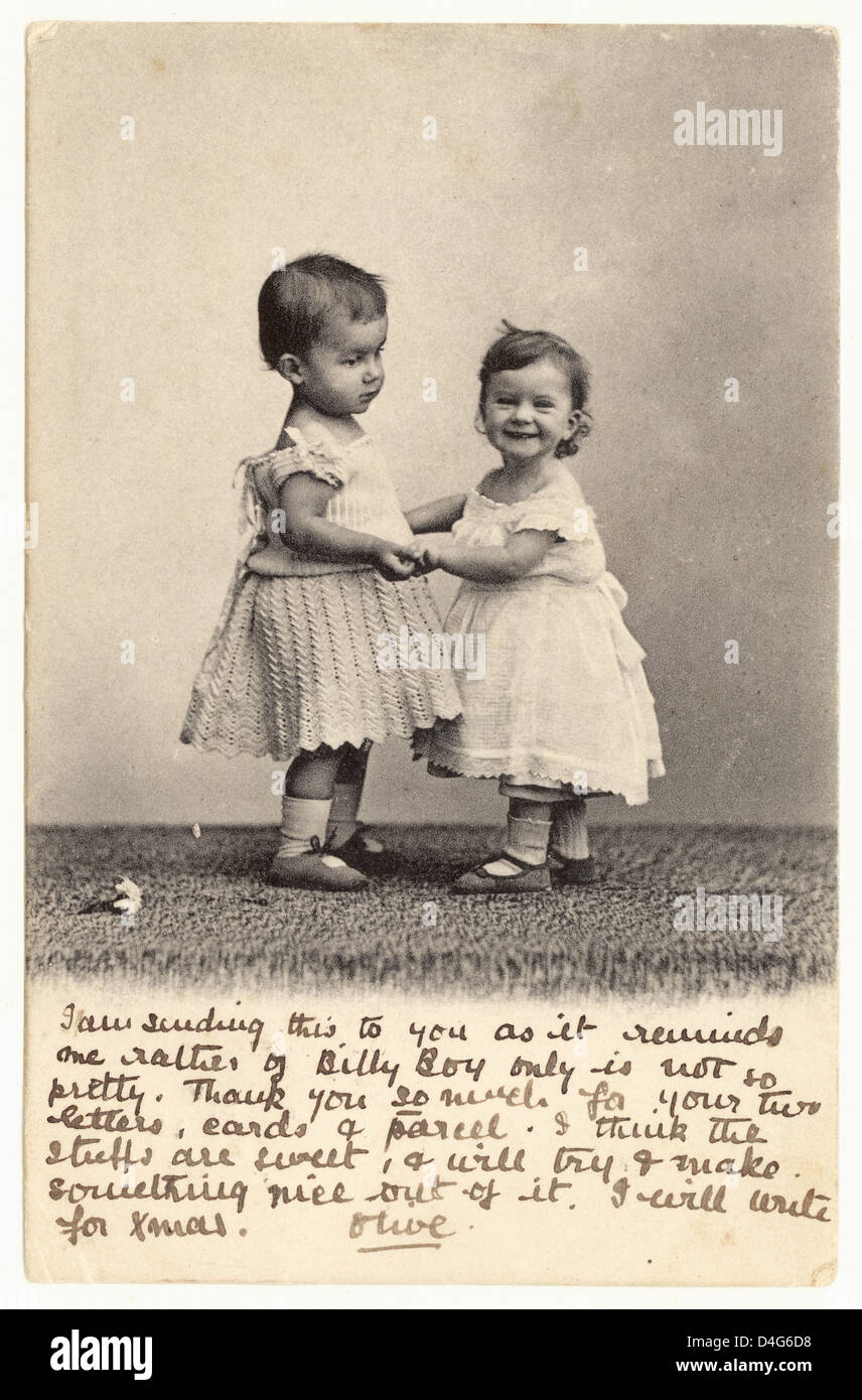 Carte postale de voeux édouardienne représentant deux bébés / tout-petits cute tenant les mains, le bébé sur la gauche est probablement un garçon portant une robe comme c'était normal à ce moment, publié en 1904 du Royaume-Uni Banque D'Images