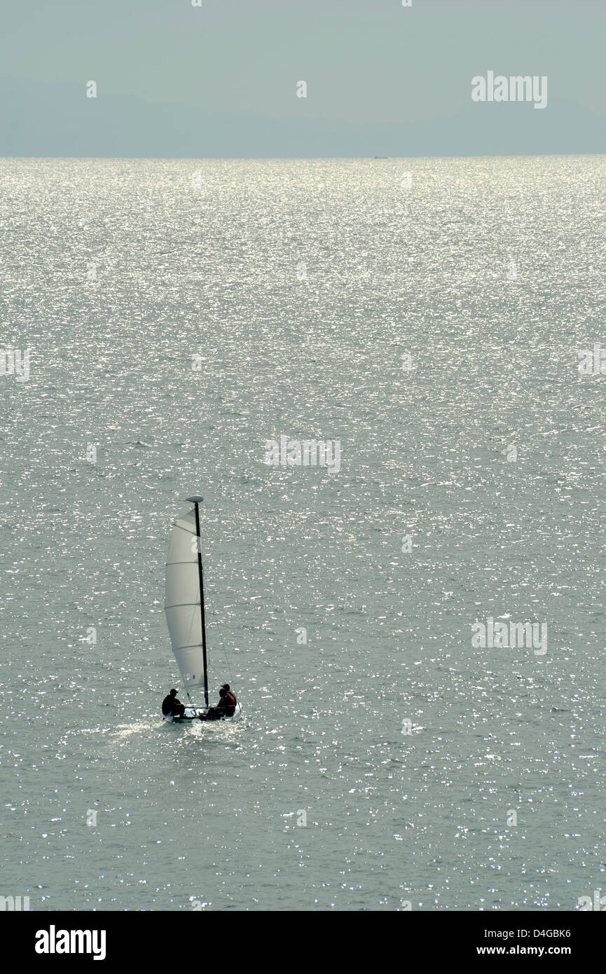 Petit voilier en direction de la mer de la rive Banque D'Images