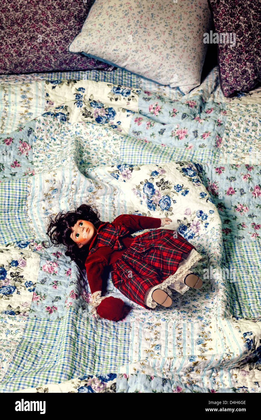 Une vieille poupée sur un lit vintage Banque D'Images