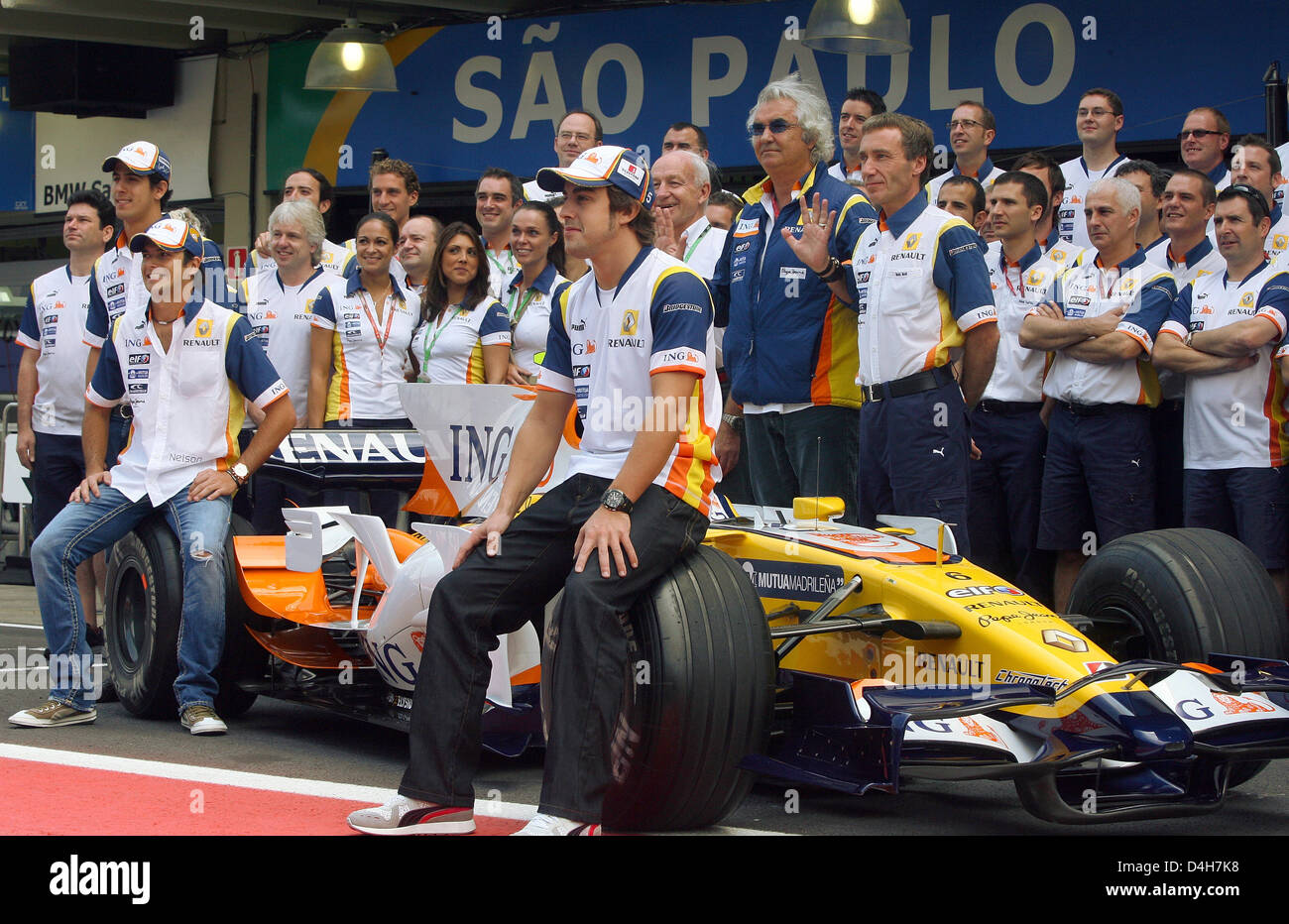 Pilote de Formule 1 espagnol Fernando Alonso (C) de Renault s'assied sur le pneu avant de sa voiture lors d'une photo de l'équipe avant le Grand Prix de Formule 1 du Brésil à la piste de course à Interlagos près de Sao Paulo, Brésil, 02 novembre 2008. Le directeur principal de l'équipe Renault Flavio Briatore italienne se trouve juste derrière lui. Photo : ROLAND WEIHRAUCH Banque D'Images