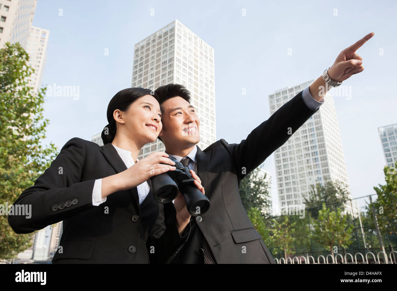 Cheerful young partenaires d'affaires avec des jumelles à la vue au centre-ville en Banque D'Images