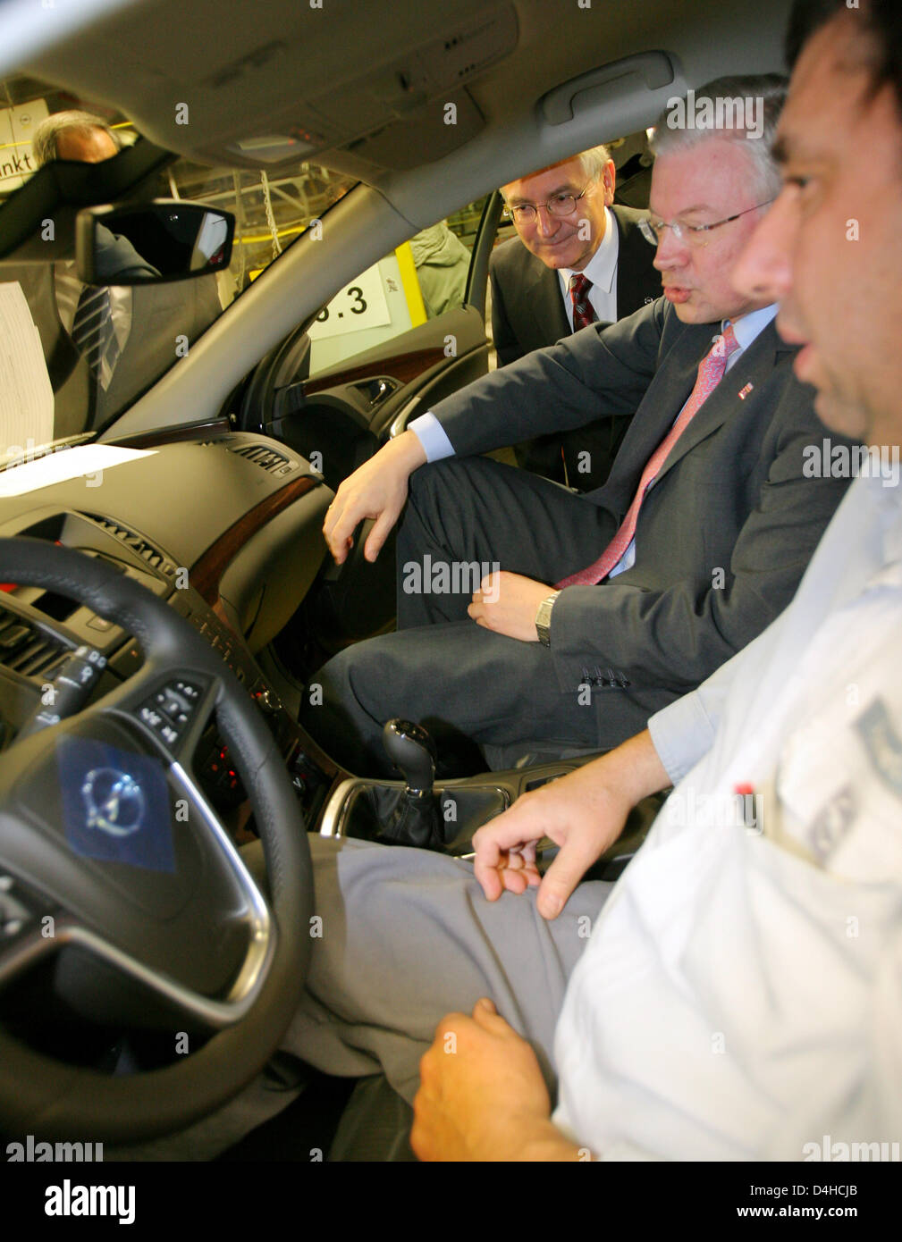 Premier Ministre de Hesse, Roland Koch (C) et la tête d'Opel Hans Demant (L) discuter avec un employé d'Opel à l'intérieur de la société nouvelle voiture de taille moyenne Insignia à l'usine de Rüsselsheim, Allemagne, 03 décembre 2008. Le constructeur automobile allemand Opel a rencontré des difficultés en raison d'une crise de société mère, General Motors (GM). Opel a demandé de l'aide dès lors que peuvent être GM sur le point de se coucher. Le constructeur automobile cherche un bai Banque D'Images