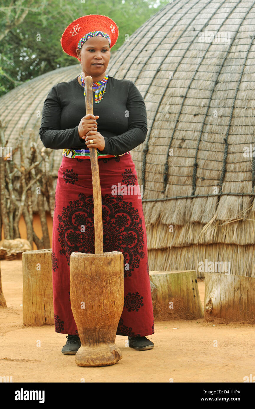 Personnes, femme adulte, tenue traditionnelle, femme Zulu écrasant le maïs, préparation alimentaire, village à thème Shakaland, KwaZulu-Nata, l Afrique du Sud, ethnique Banque D'Images