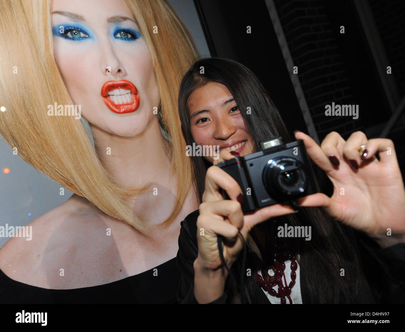 L'épouse du photographe Michel Comte, Ayako, se dresse en face d'une photographie de Carla Bruni au NRW-Forum Kultur und Wirtschaft (lit : Rhénanie Westfalian forum pour la culture et l'économie) à Düsseldorf, Allemagne, 01 février 2009. Du 01 février au 10 mai 2009, l'exposition ?Michel Comte - 360 degrés ? Montre les œuvres de la Zurich-photographe spécialisé dans les portraits, f Banque D'Images