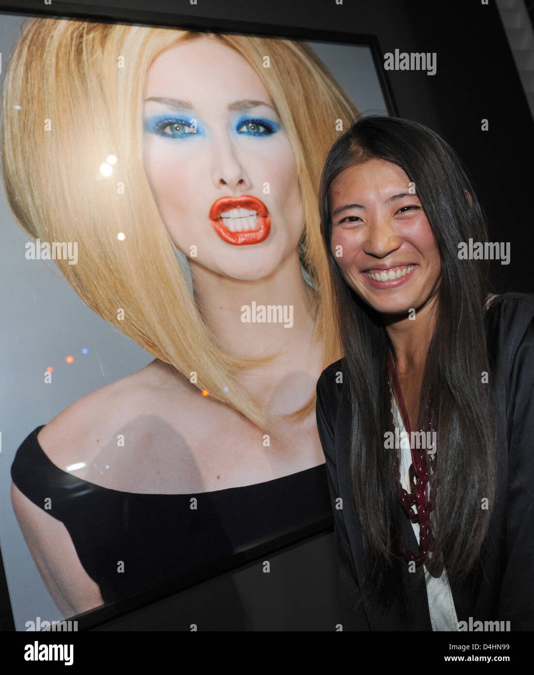 L'épouse du photographe Michel Comte, Ayako, se dresse en face d'une photographie de Carla Bruni au NRW-Forum Kultur und Wirtschaft (lit : Rhénanie Westfalian forum pour la culture et l'économie) à Düsseldorf, Allemagne, 01 février 2009. Du 01 février au 10 mai 2009, l'exposition ?Michel Comte - 360 degrés ? Montre les œuvres de la Zurich-photographe spécialisé dans les portraits, f Banque D'Images