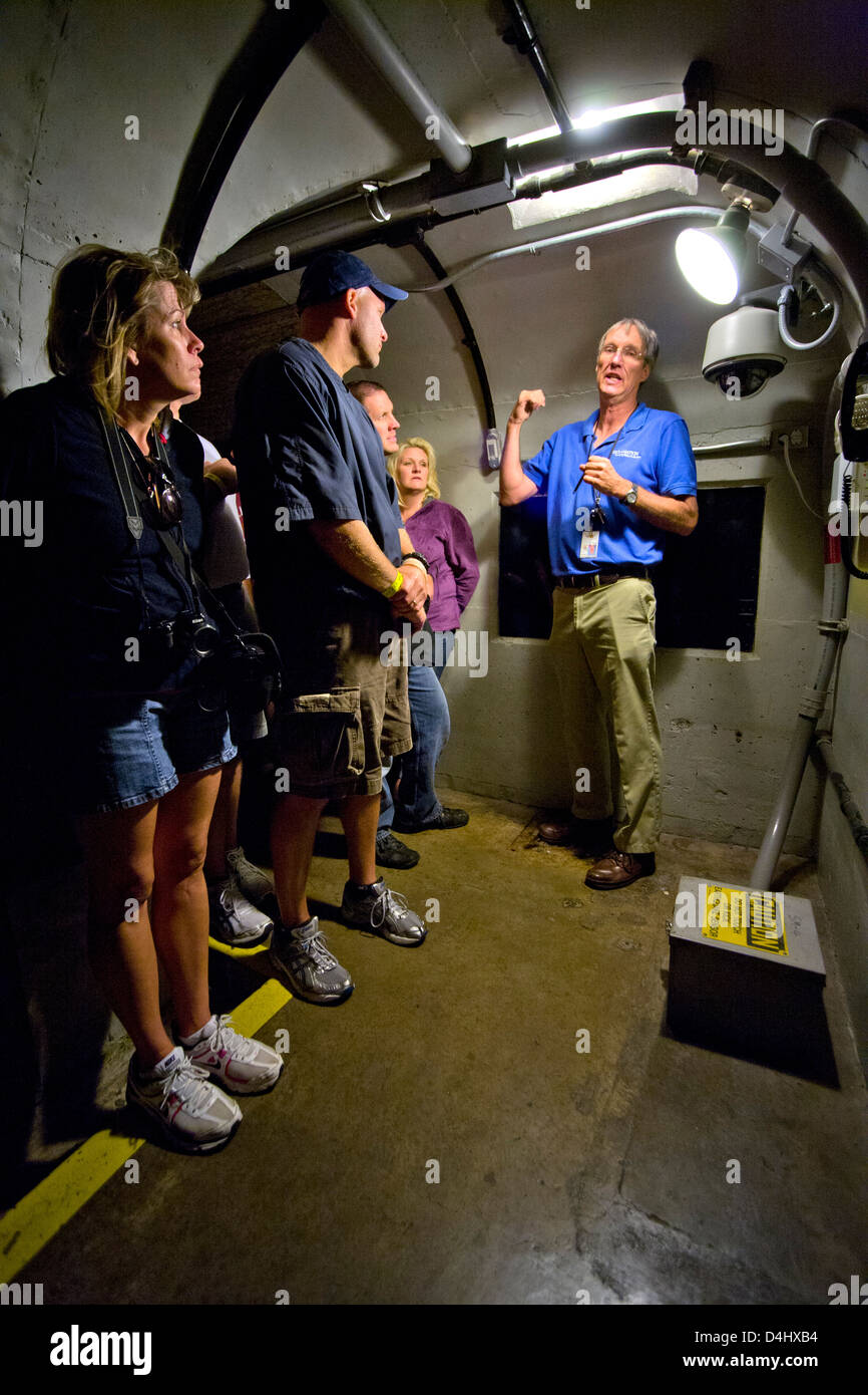 Un guide explique en uniforme un tremblement de détecteur (en bas à droite) à un groupe de touristes dans un tunnel d'inspection à Hoover Dam Banque D'Images