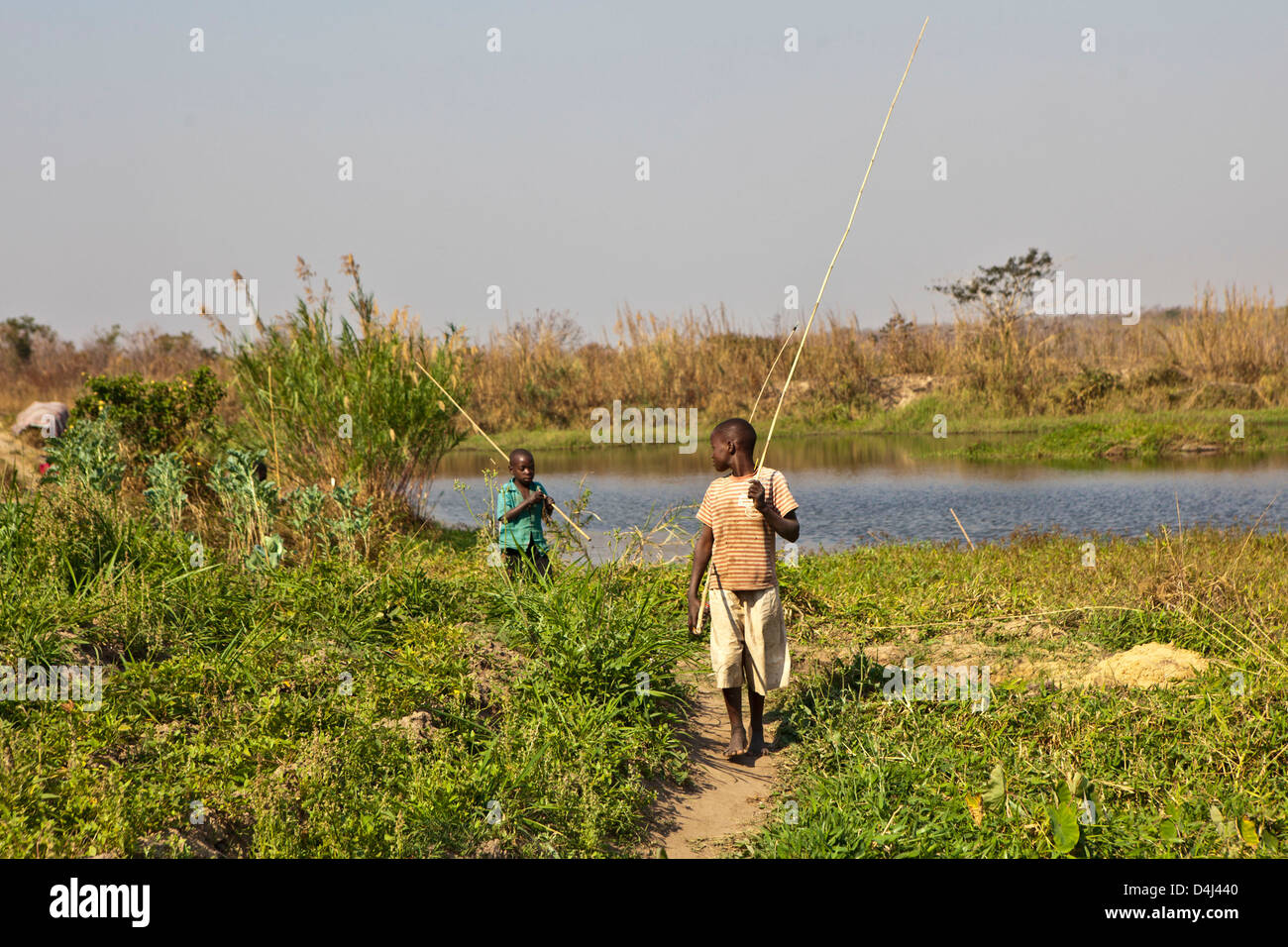 Des jeunes Africains de la pêche sur le lac de Kubatsirana Farm géré par un organisme de bienfaisance qui aident à fournir de la nourriture et le travail, au Mozambique. Banque D'Images