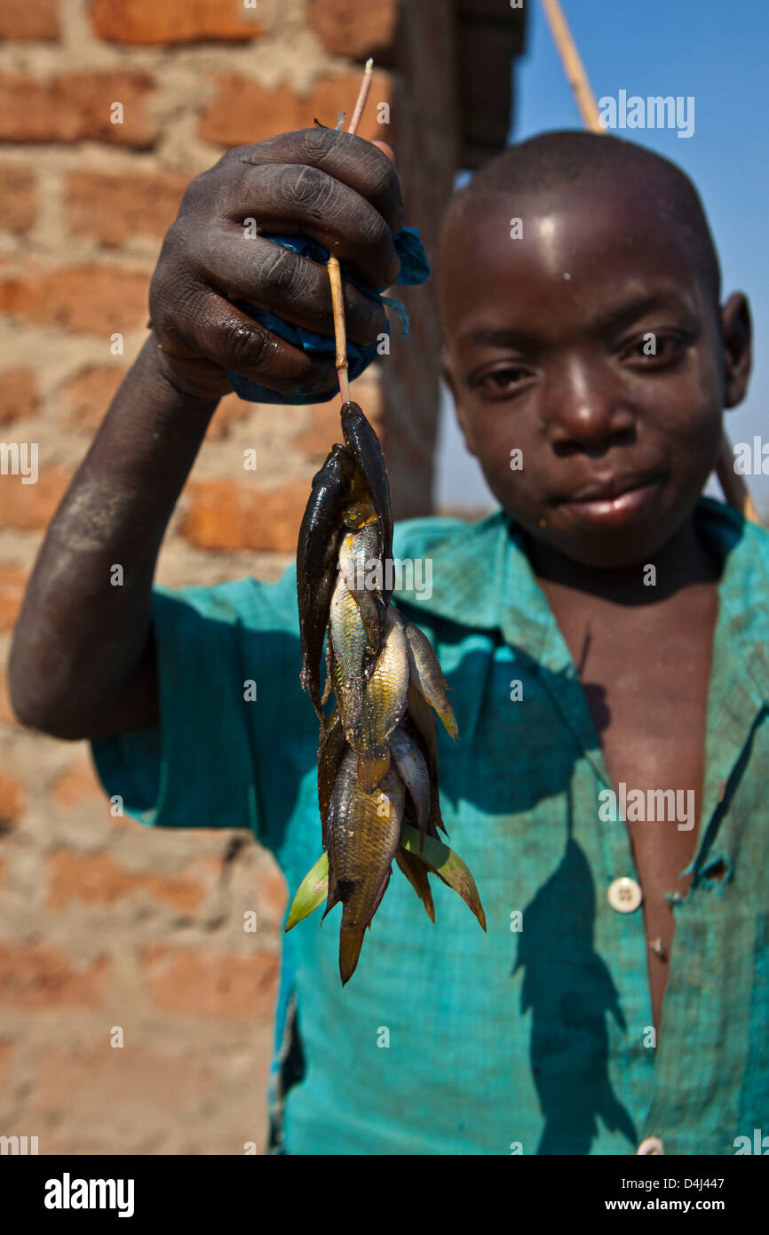 African boy montre son poisson à la ferme Kubatsirana exécuter par un organisme de bienfaisance qui aident à fournir de la nourriture et le travail, au Mozambique. Banque D'Images