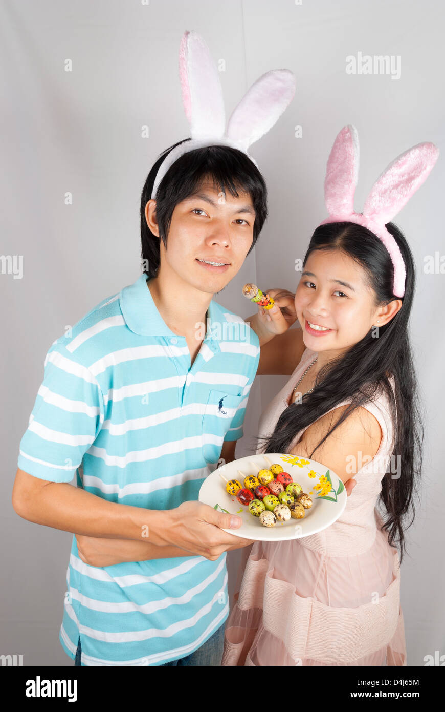 Les amoureux de l'Asie bunny tenir les oeufs de Pâques percé. Banque D'Images