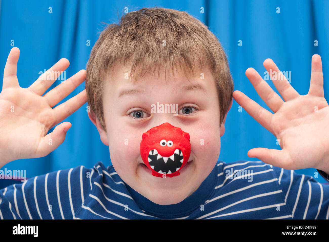 Un garçon de neuf ans portant un nez rouge pour comic relief Banque D'Images