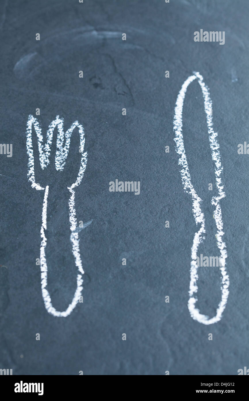 Simple dessin du couteau et fourchette sur fond sombre Banque D'Images