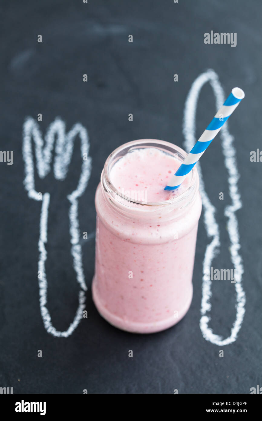 Smoothie aux fraises de paille à rayures avec fourchette et couteau dessin à la craie Banque D'Images