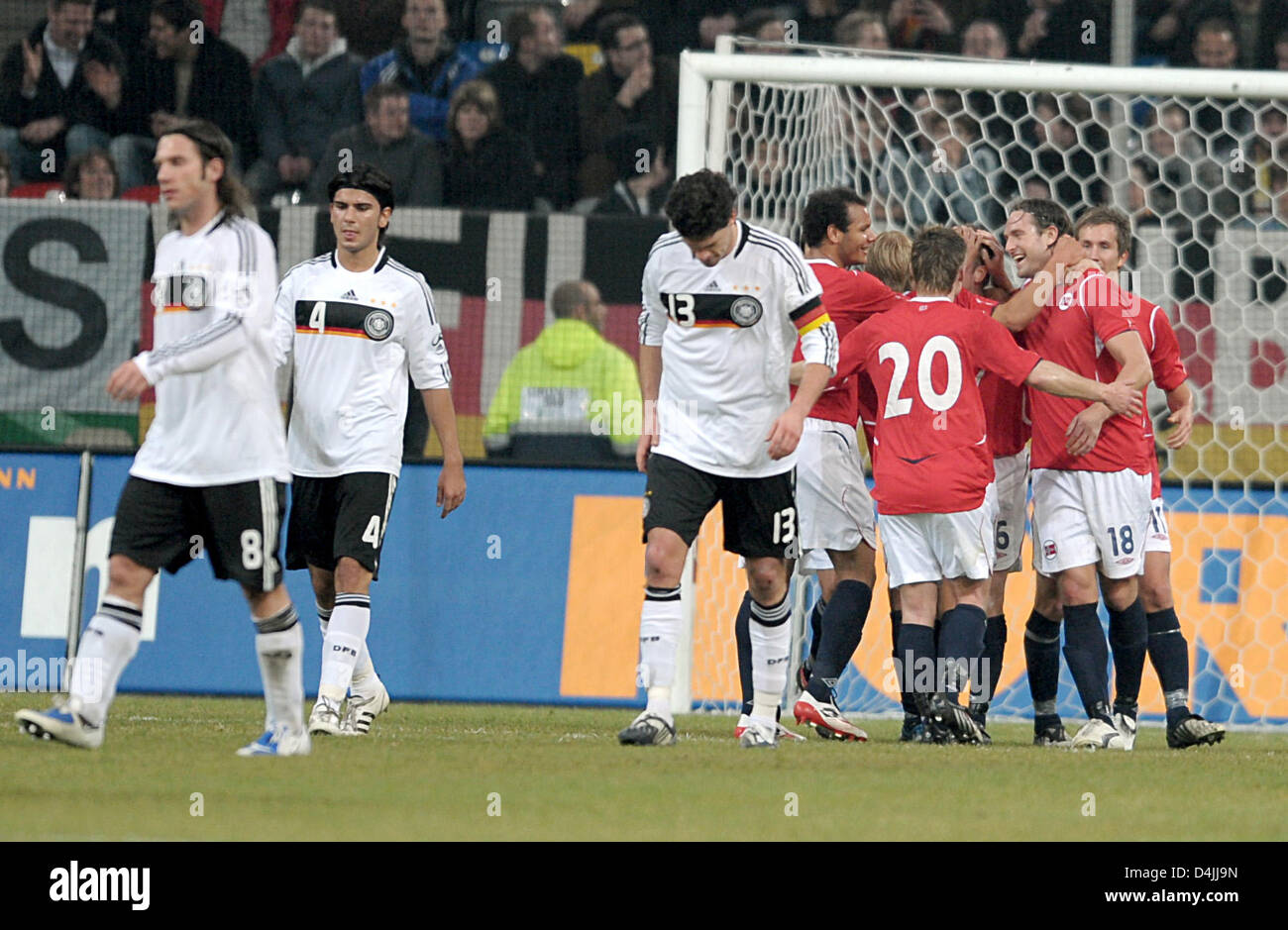 Les joueurs allemand Torsten Frings (L-R), Serdar Tasci et Michael Ballack quittent la surface de réparation alors que les joueurs norvégiens célèbrent leur victoire 1-0 lors du match international à LTU Arena de Düsseldorf, Allemagne, 11 février 2009. La Norvège a remporté le test match 1-0. Photo : Federico Gambarini Banque D'Images