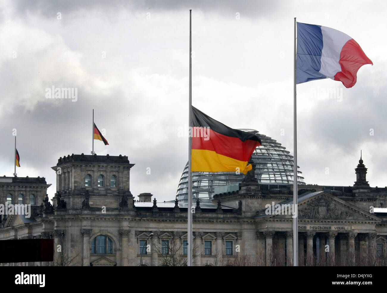 Le drapeau allemand (L) vole à mi-mât à côté du drapeau français devant le bâtiment Reichstags à Berlin, Allemagne, 12 mars 2009. 17-year-old rampage tireur Tim K. shot 15 morts dans l'école secondaire ?Albertville ? À Winnenden et pendant son escapade sur Mars 11, dont neuf élèves et trois professeurs de l'école. Plusieurs policiers, les élèves et les passants étaient également Banque D'Images