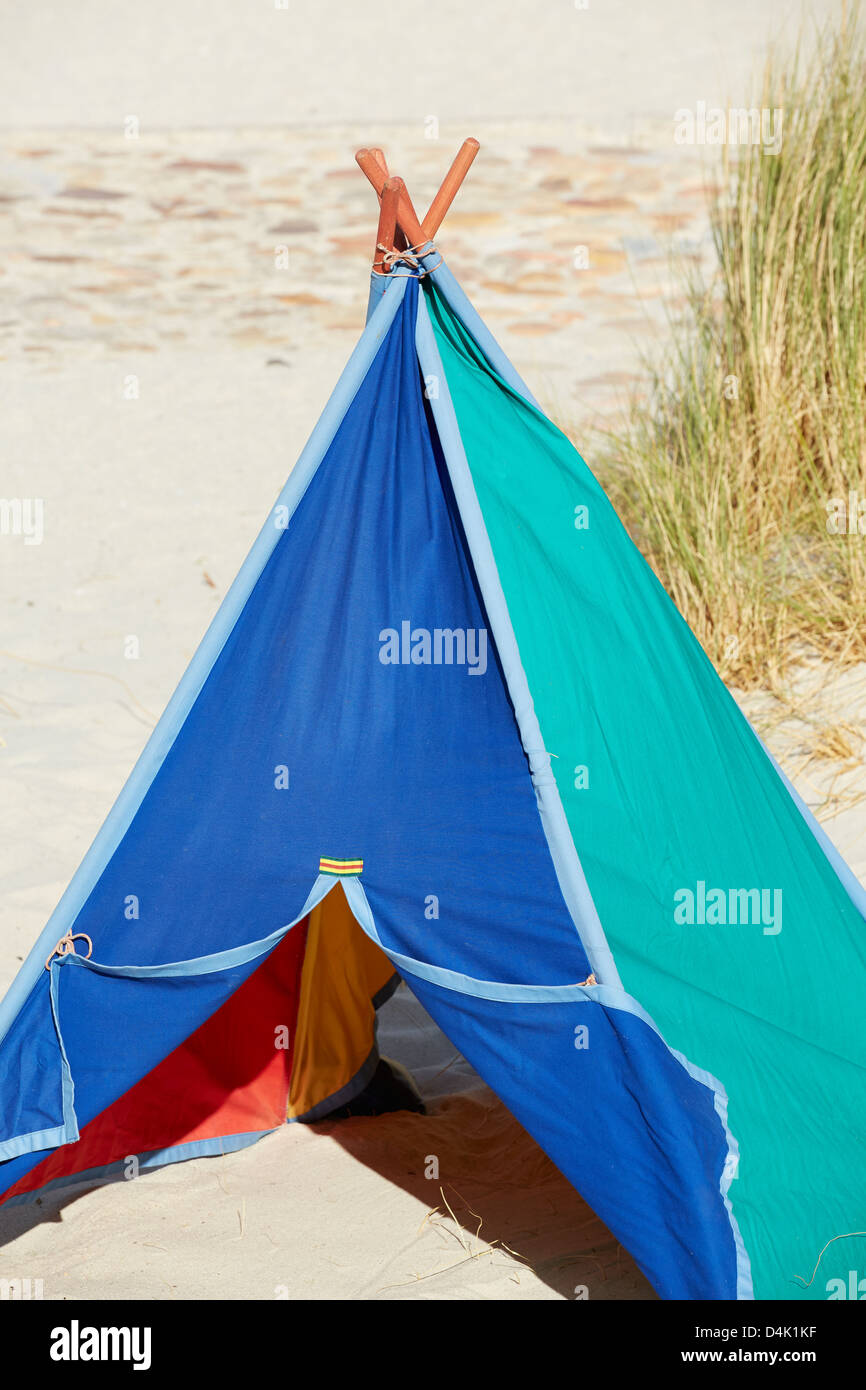 Tente Tipi multicolores plage sable mer herbe Banque D'Images