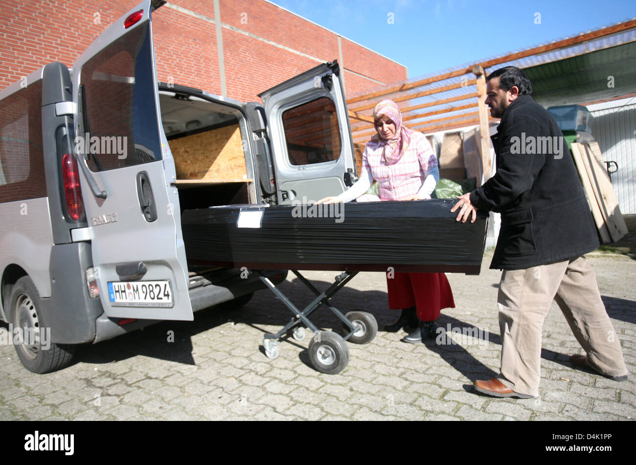 Undertaker Vildane Abdelatif turc et un de ses employés pousser un cercueil dans une voiture à Hambourg, Allemagne, 17 mars 2009. Abdelatif est le premier entrepreneur turc en Allemagne. Le commerçant de gros et de détail a fondé le funérarium Uludag-Cenaze avec son père en 1996. Non seulement les gens turcs sont ses clients. L'une de ses tâches principales est d'organiser le transport de la Banque D'Images