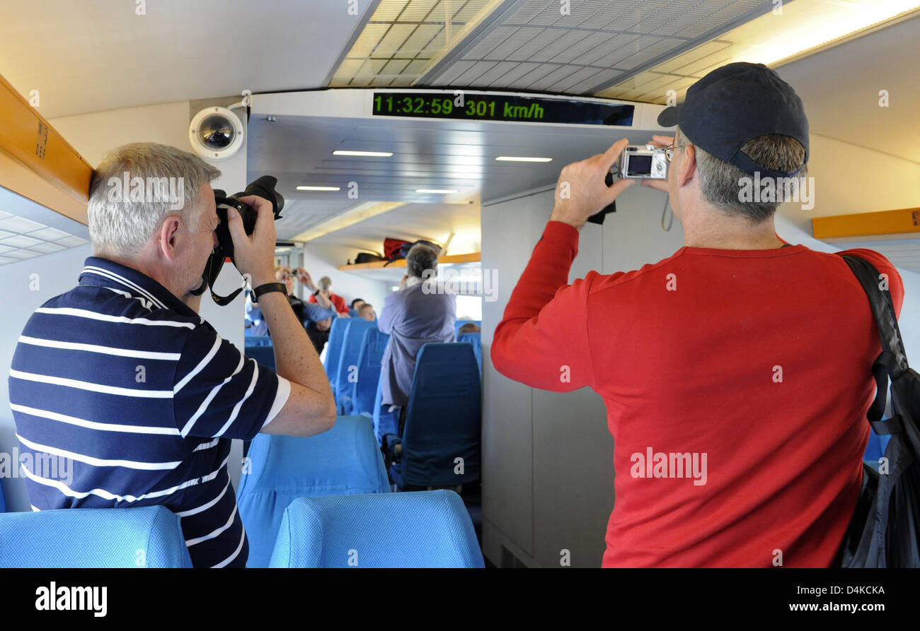 Deux passagers de sexe masculin de prendre des photos de l'indicateur de vitesse numérique dans le Shanghai Maglev Train (Transrapid) à Shanghai, Chine, le 21 avril 2009. Photo : Marijan Murat Banque D'Images