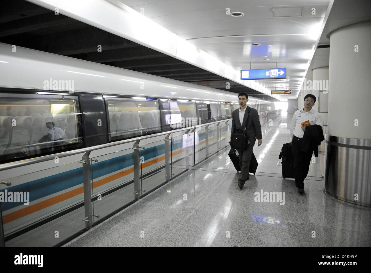 Deux passagers à pied le long de la Shanghai Maglev Train Transrapid () à l'aéroport de Pudong à Shanghai, Chine, 21 avril 2009. Photo : Marijan Murat Banque D'Images