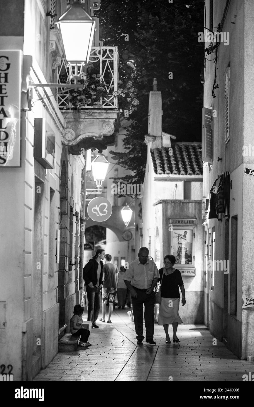 L'âge moyen d'un couple en train de marcher dans les rues de la ville sur l'île croate de Krk Krk. Krk est une destination touristique très populaire. Banque D'Images