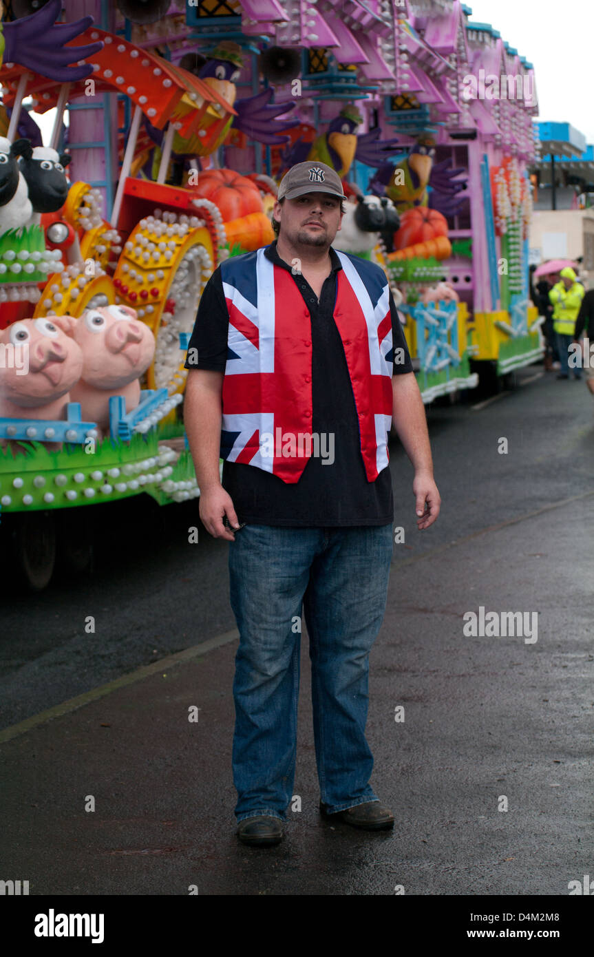 Dans l'homme union jack jacket se place en avant d'un carnaval panier Banque D'Images