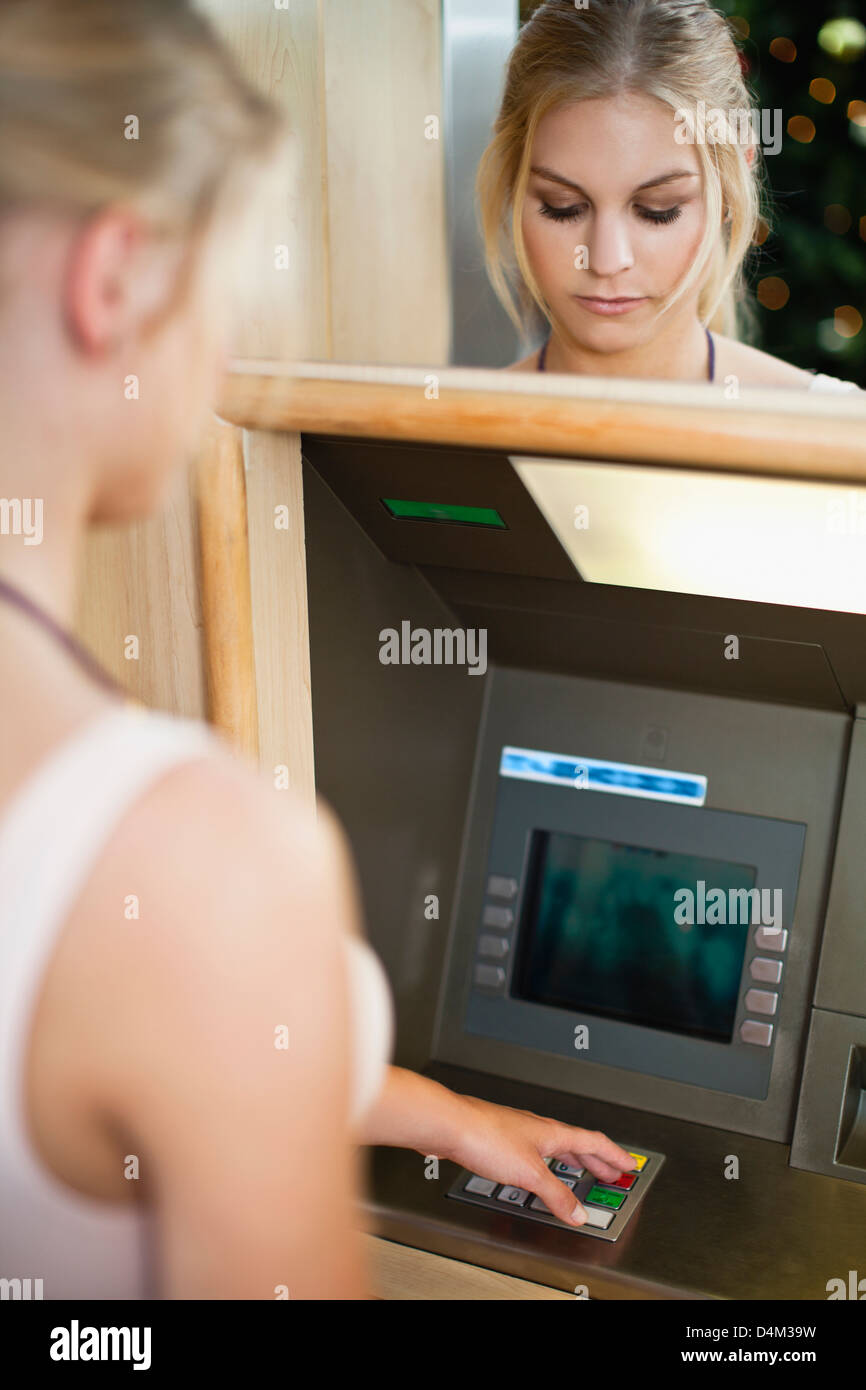Femme à l'aide du clavier sur ATM Banque D'Images
