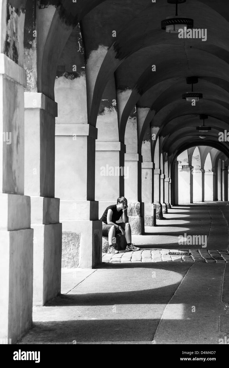 Fatigué de jeunes femelles'prend un reste parmi les arches dans le château historique de Prague, République Tchèque Banque D'Images