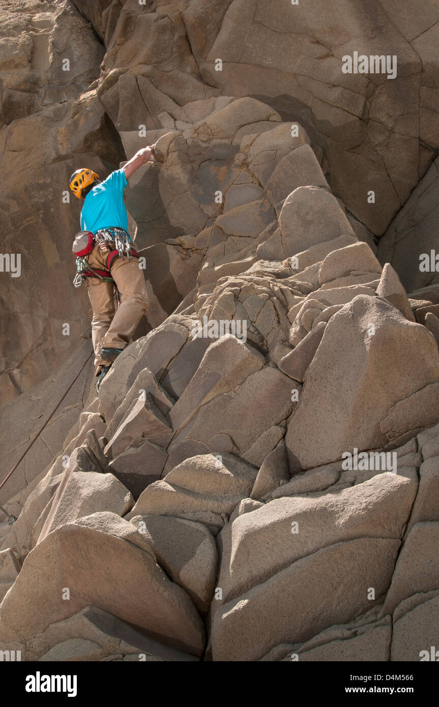Rock climber scaling jagged cliff Banque D'Images
