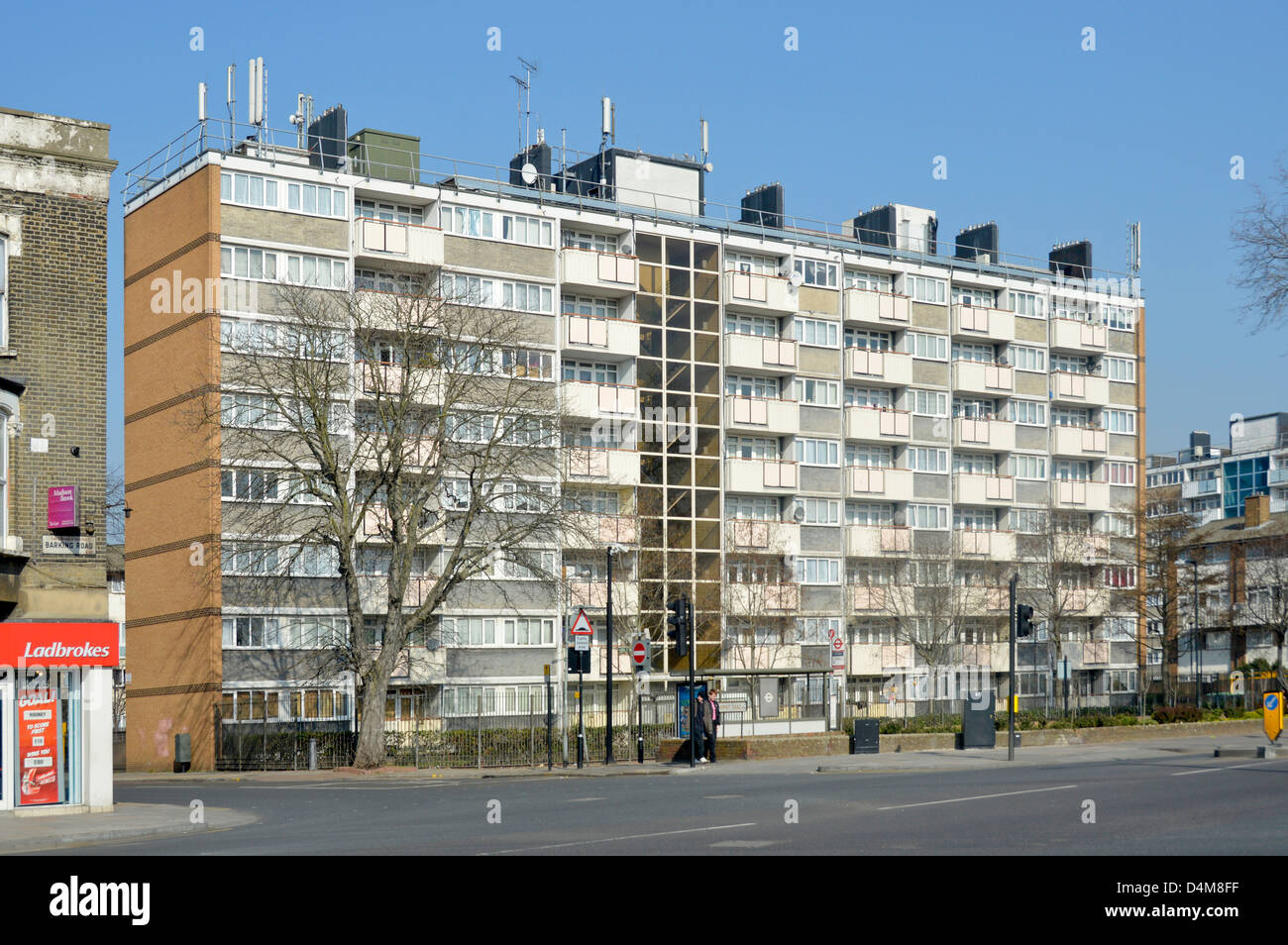 Bloc d'appartements dans une région défavorisée avec Ladbrokes betting shop sur le coin de la rue adjacente Banque D'Images